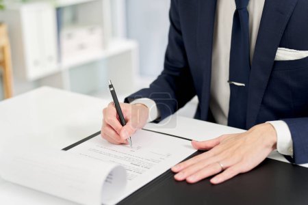 Hand eines Geschäftsmannes bei der Unterzeichnung eines Vertrages