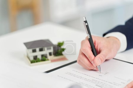 Téléchargez les photos : Homme d'affaires signant un contrat immobilier - en image libre de droit