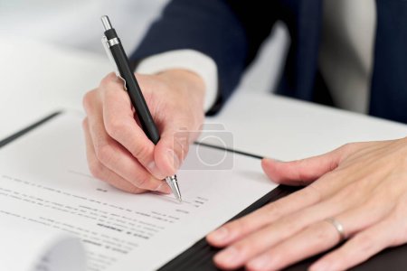 Hand eines Geschäftsmannes bei der Unterzeichnung eines Vertrages