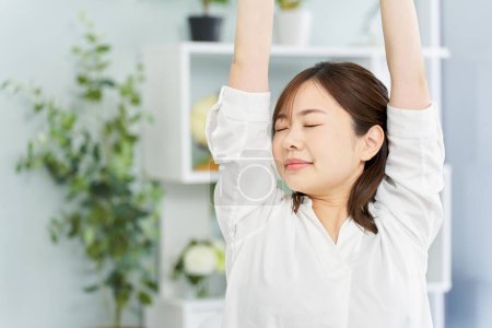 A woman stretching in her room