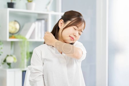 A woman suffering from stiff shoulders