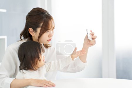 Maman prend smartphone loin de l'enfant