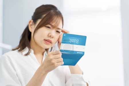 A woman who is troubled by looking at her bank passbook
