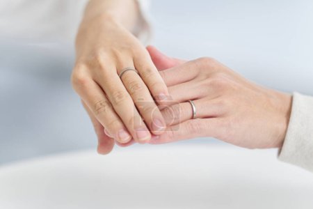 Couple holding hands and showing wedding rings