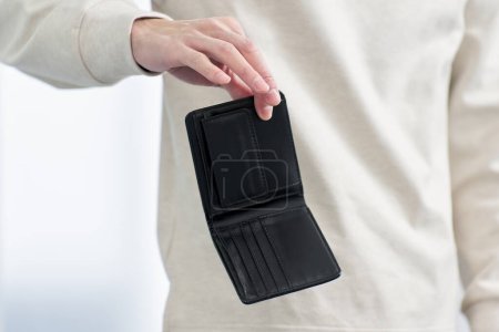 Foto de Un hombre sosteniendo una billetera sin dinero - Imagen libre de derechos