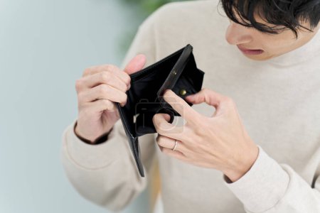 Foto de Un hombre sosteniendo una billetera sin dinero - Imagen libre de derechos