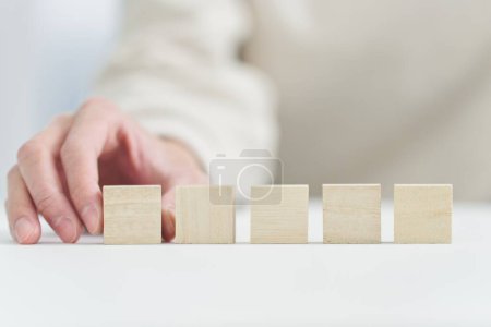 Hand hält einen massiven Holzblock