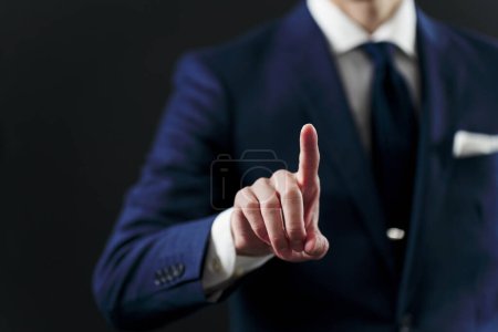 Businessman's hand pointing on black background