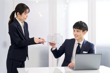 A business person checking the work of his subordinates