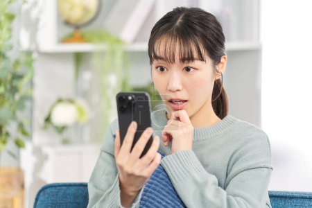 Surprised woman looking at smartphone
