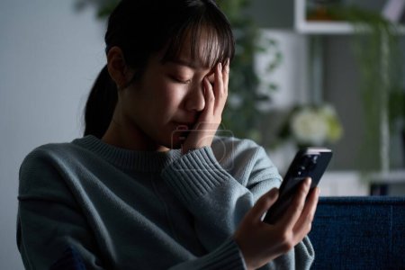 Una mujer deprimida mirando su smartphone