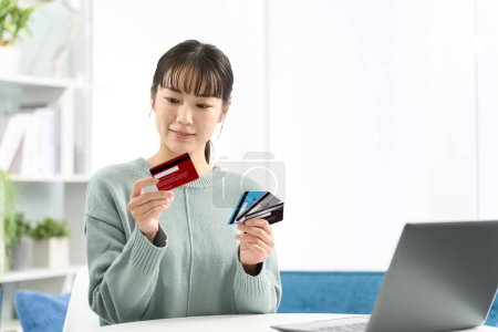 Asiatin wählt eine Kreditkarte