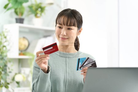 Foto de Mujer asiática eligiendo una tarjeta de crédito - Imagen libre de derechos