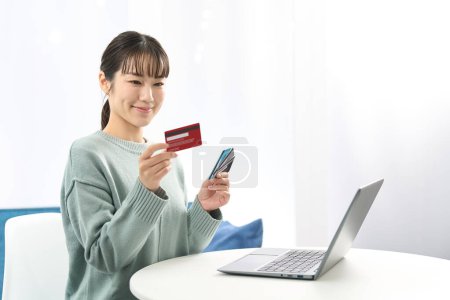 Mujer asiática eligiendo una tarjeta de crédito