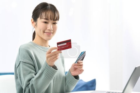 Foto de Mujer asiática eligiendo una tarjeta de crédito - Imagen libre de derechos