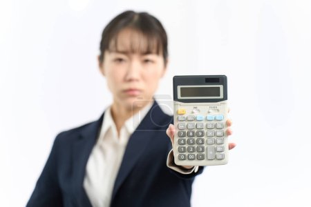 Eine wütende Frau rechnet mit einem Taschenrechner