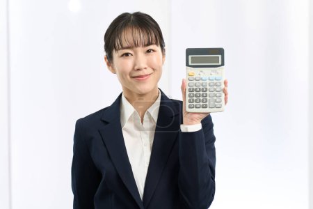 Business woman smiling and holding a calculator