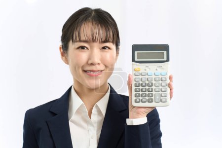 Business woman smiling and holding a calculator