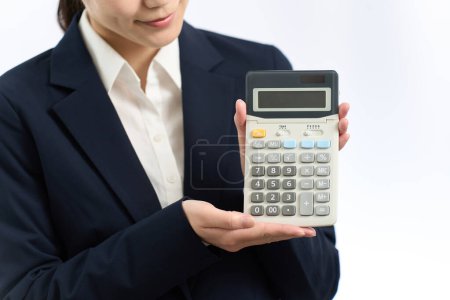 Femme d'affaires montrant une calculatrice
