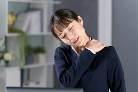 Eine Geschäftsfrau mit steifen Schultern wegen Überstunden