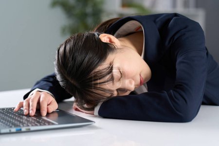 Téléchargez les photos : Femme d'affaires s'endormir après avoir travaillé de longues heures - en image libre de droit