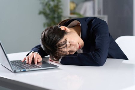 Téléchargez les photos : Femme d'affaires s'endormir après avoir travaillé de longues heures - en image libre de droit