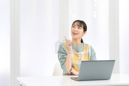 Eine Frau mit Schürze kommt bei der Arbeit am Computer auf gute Ideen