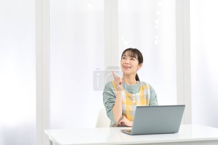 Eine Frau mit Schürze kommt bei der Arbeit am Computer auf gute Ideen