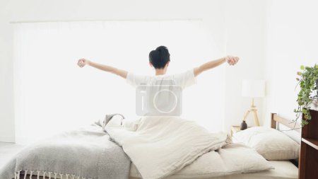 A man wakes up and stretches