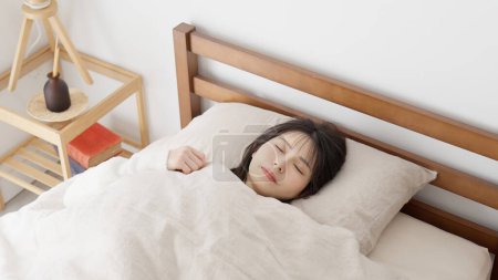 Foto de Asiático mujer durmiendo en cama - Imagen libre de derechos