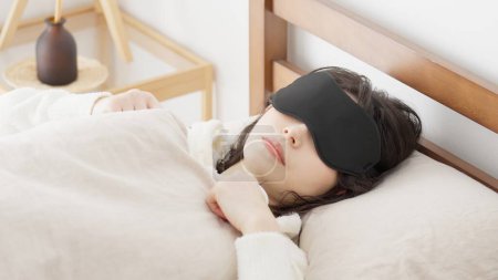 Eine Frau schläft mit Augenmaske in einem hellen Raum
