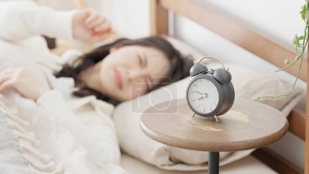 A woman woken up by an alarm clock