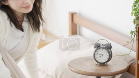 Mujer levantándose de la cama por la mañana