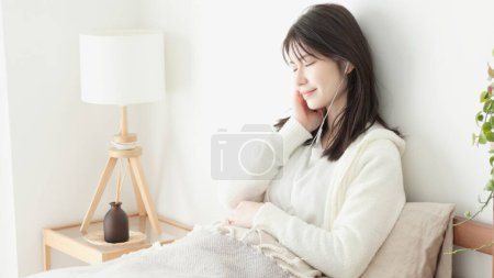 woman listening to music in bed