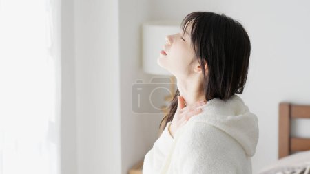 Eine Frau kümmert sich um ihre schmerzende Schulter