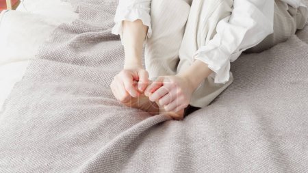 A woman rubbing her cold feet