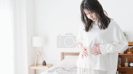 Une femme soucieuse de son estomac potelé