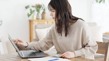 A woman researching and calculating costs on the Internet