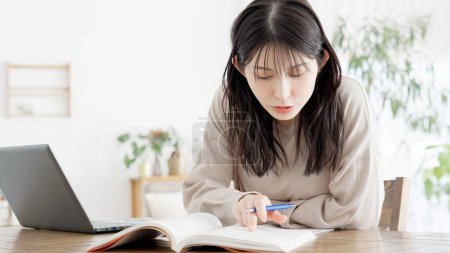 Photo for A woman studying for a qualification at home - Royalty Free Image