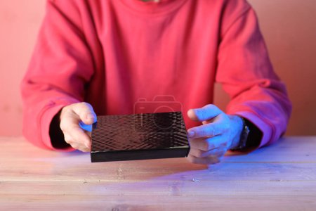 Photo for Laptop optical drive in hands over table and colored background - Royalty Free Image