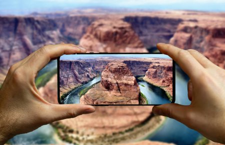 Photo for Tourist taking a picture with a mobile phone at the horseshoe bend in Arizona, USA. - Royalty Free Image