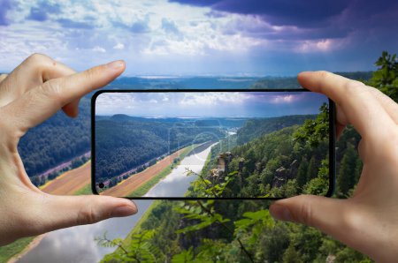 Foto de Turista tomando una foto con un teléfono móvil del río Elba en las montañas de arenisca en Sajonia, Alemania. - Imagen libre de derechos