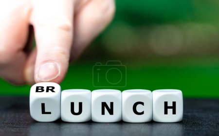 Foto de Preferring lunch or brunch? Hand turns dice and changes the word lunch to brunch. - Imagen libre de derechos