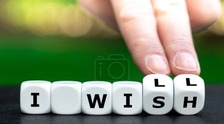 Téléchargez les photos : Hand turns dice and changes the expression 'I wish' to 'I will'. - en image libre de droit