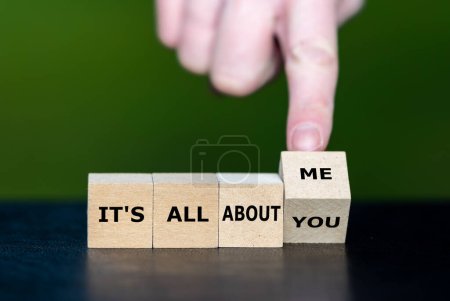 Téléchargez les photos : Hand turns dice and changes the expression 'it's all about you' to 'it's all about me'. - en image libre de droit