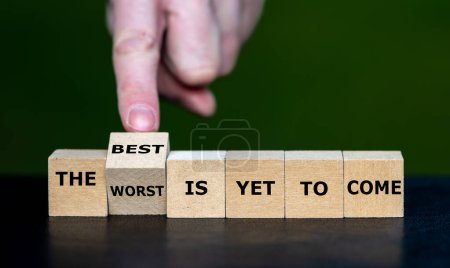 Téléchargez les photos : Hand turns dice and changes the expression 'the worst is yet to come' to 'the best is yet to come'. - en image libre de droit
