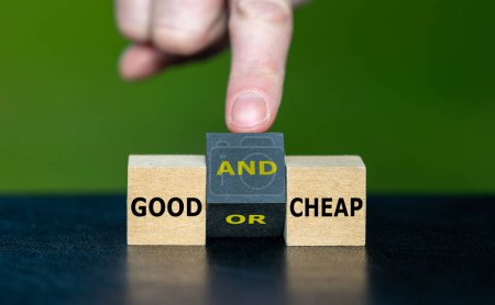 Photo for Hand turns wooden cube and changes the expression 'good or cheap' to 'good and cheap'. - Royalty Free Image