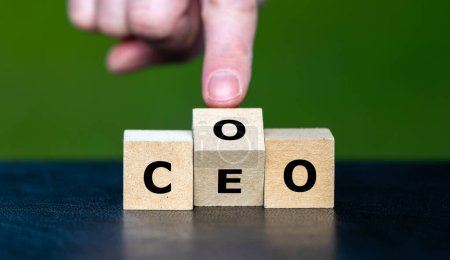 Photo for Hand turns cube and changes the abbreviation COO (chief operating officer) to  CEO (chief executive officer). - Royalty Free Image