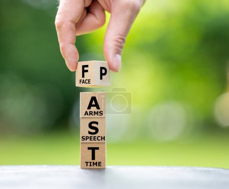 Photo for A stack of wooden cubes forms the expression FAST. FAST stands for "facial drooping", "arm weakness", "speech difficulties" and "time to call emergency services". - Royalty Free Image