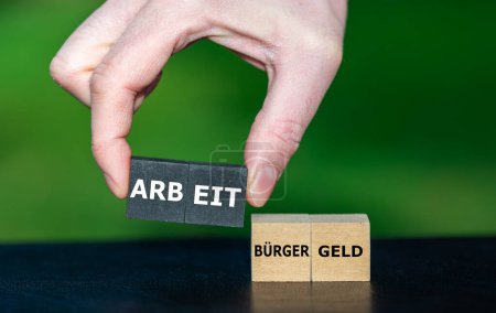 Symbol for the discussion in Germany if you receive more money with social welfare compared to a job income. and picks the cubes with the word 'Arbeit' (work) instead of 'Buergergeld' (social welfare)